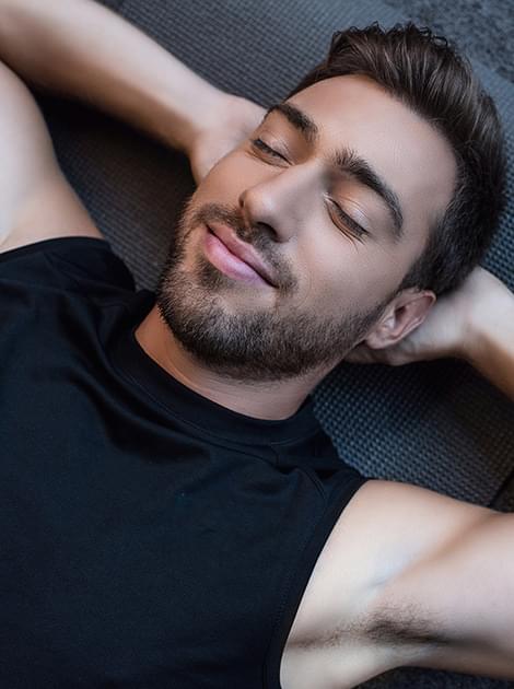 Photo of youn man relaxing on yoga mat